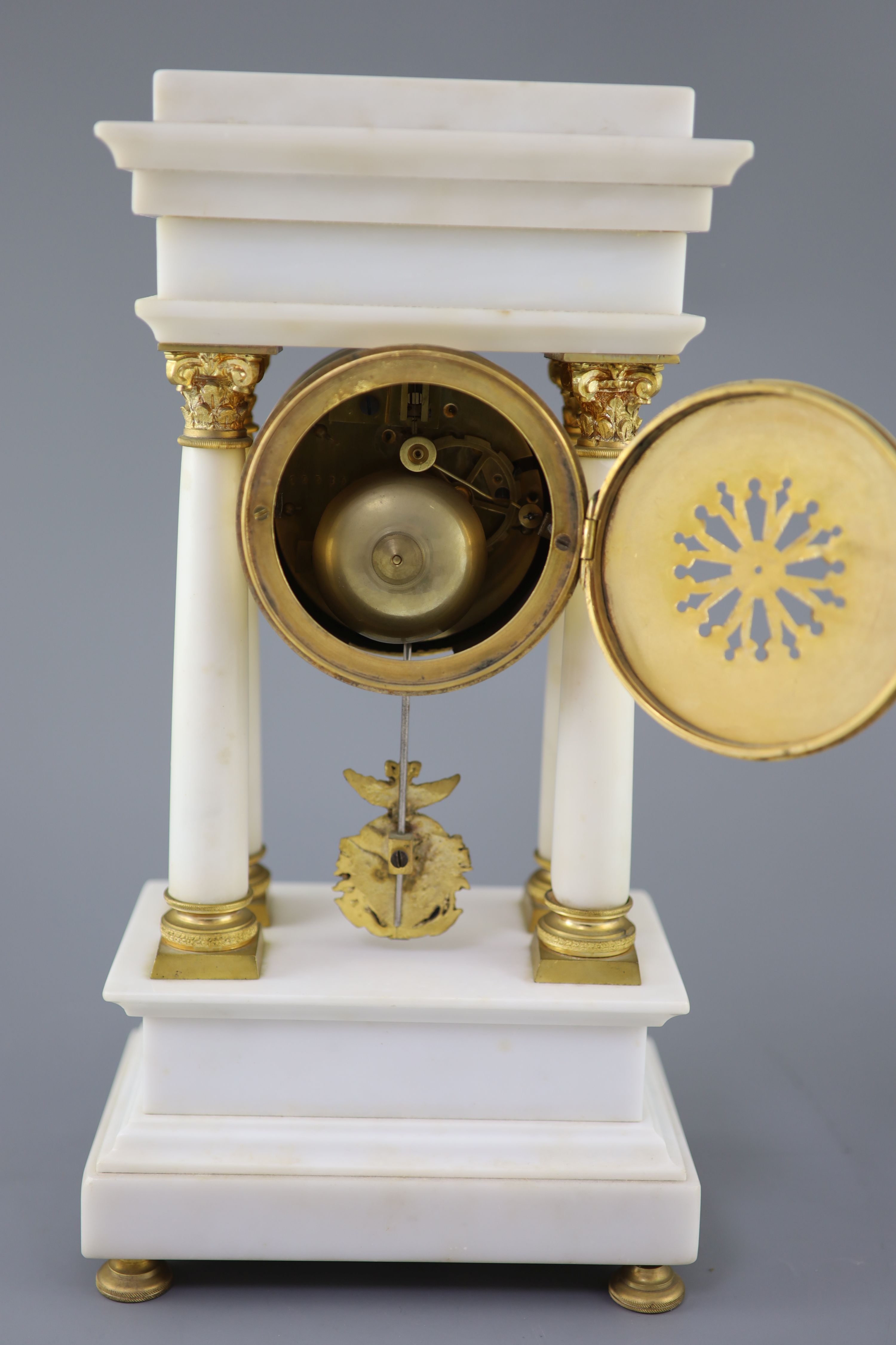 A Louis XVI style ormolu mounted white marble clock garniture, clock 14.5in. urns 13.75in.